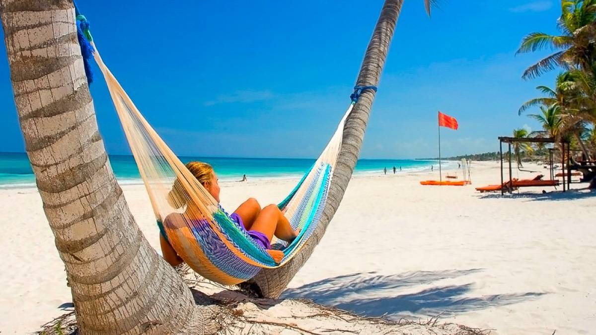 Junge Frau in der Hängematte zwischen Palmen am Strand | © alf75, iStockphoto.com / Chamäleon Junge Frau in der Hängematte zwischen Palmen am Strand | © alf75, iStockphoto.com / Chamäleon