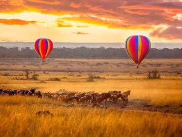 Sonnenaufgang in der Masai Mara mit Ballons und Gnuherde